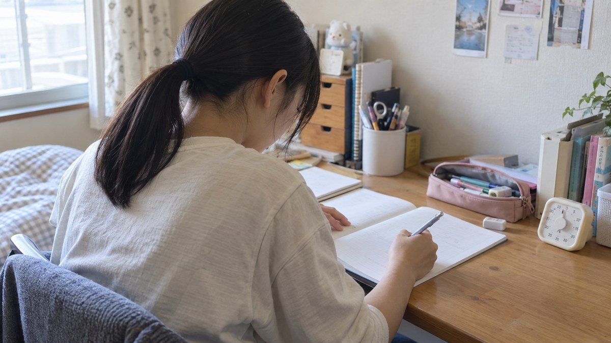 自宅の机でタイマーを置いて勉強する中学生の写真風イメージ